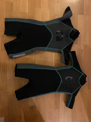 Två våtdräkter för barn  - Våtdräkter i neopren, fint skick (en är nog oanvänd, men jag ser ingen skillnad på dem). Storleksmärkningen säger 8 år men jag skulle säga att de funkar från ca 5 år, beroende på hur tajt man föredrar. Köpare betalar frakt.