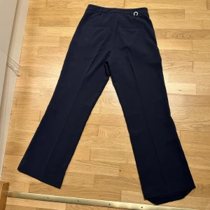 Stockhlm kostymbyxa - Säljer dessa kostymbyxor från märket stockhlm från MQ pga alldeles för stora. Använda endast en gång. Storlek 34 men skulle mer säga att den sitter som en 38 eller en 36:a. Ska vara highwaist men går att ha de som low eller midwaist Ordinarie pris 699 kr 