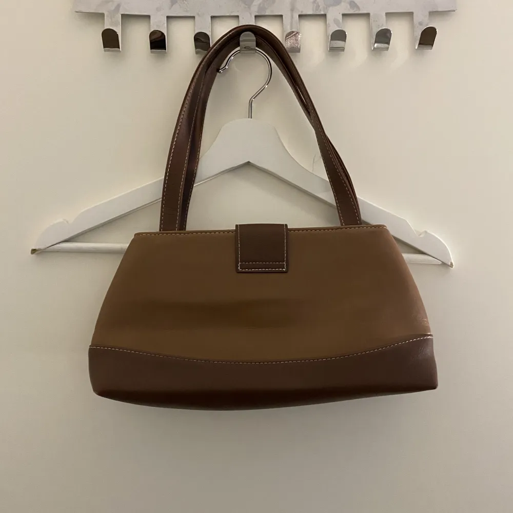  en liten brun handväska . Väskor.