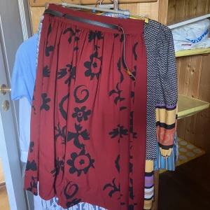 Kjol - Medellång kjol. Skärpet ingår, skitnsygh, tajt k midjan.