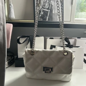 Vit handväska  - Fin vit väska med ett större tack och ett lite mindre, bandet är sjysterbart.💗