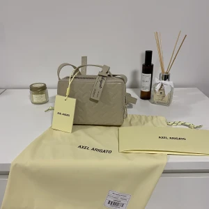 Axel Arigato väska  - Axel Arigato beige läderväska med justerbara band och one size i storlek   Hör gärna av dig vid några fundering,    3500kr + frakt 