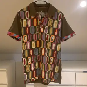 En multifärgad och brun kortärmad skjorta.