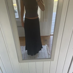 Lågmidjad kjol - Lågmidjad svart långkjol i sidenaktigt material, storlek M men passar mig som har XS💕