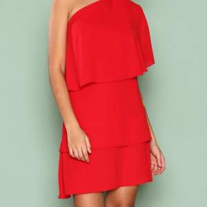 Enaxlad röd kort klänning med volanger från Nelly. Perfekt nu till sommaren ❤️Aldrig använd, nyskick!