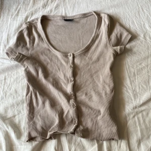 Beige t-shirt - Säljer denna fina ribbade topp. Då den inte kommer till användning. Vid intresse kontakta mig.