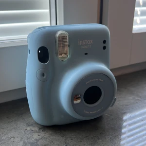 Kamera - Fujifilm Instax mini 11, kamera. Köpt i början av året men inte kommit till så stor användning. Inga skador på den varken ytliga eller funktionärt.   Köpt för 849kr men inte riktigt aning om hur mkt jag ska sälja den för. Kom dm för prisförslag diskussion
