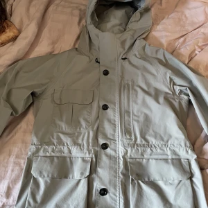 Woolrich Vindjacka - Säljer min Woolrich vind/höst-jacka, som jag köpte i vintras. Jackan är tunn och perfekt för blåst och regn, då materialet är Gore-Tex.   Inga synliga skador, det enda är att de nedre fickorna är lite slitna, men inget som syns som sagt. 