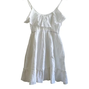 Kort Sommarklänning  - VARAN KAN KÖPAS DIREKT PÅ VÅR HEMSIDA, ettmarke.se 🌟 Färg: Vit. Modell: Kort. Storlek: Uppskattad storlek XS/34 då ingen lapp finns. Kan passa fler storlekar då den har justerbara axelband. Totallängd (utan axelband): Ca 69cm  Totallt ( axelband) Ca 78cm