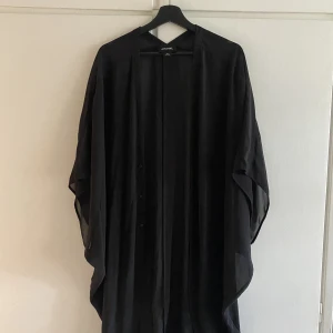 Stilren kaftan  - En svart luftig kaftan i mjuk chiffong i storlek XS/S, oversized fit, skulle benämna den som M/L. Använd ett fåtal gånger, inga synliga tecken på användning 