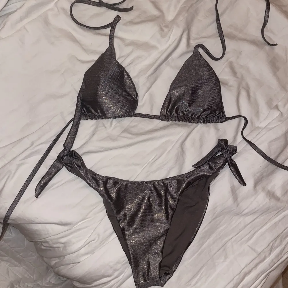 Silvrig bikini som är köpt från en strandbutik i Italien. Bikinin har längre band som går att knyta flera varv runt midjan. Helt oanvänd då den tyvärr inte passade. Storlek M . Övrigt.