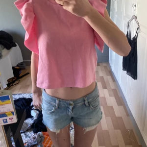 Tröja  - Fin tröja med volangärmar, fin färg som lätt kombineras med ett var shorts eller byxor 