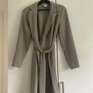 Olivgrön kavajklänning  - En ljusgrön kavajklänning från märket ICHI i storlek 34. Den är ungefär knälång på mig som är 168cm.  Köparen står för frakten🌸