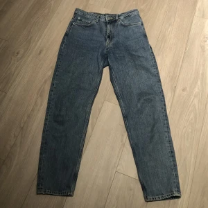 Blåa Jeans - Skit snygga jeans från weekday ända anledningen till varför jag säljer dem är för att dem är för korta. Skulle säga att dem har en mom jeans form. Frakt adderas på det nuvarande priset.