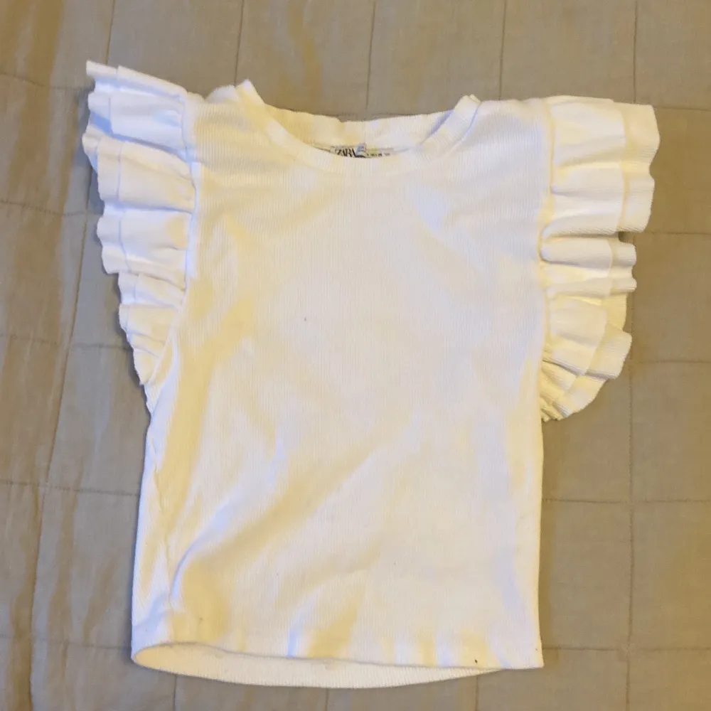 jag säljer denhär jättefina basic vita t-shirten men volang ⚡️ anledning till varför jag säljer den är för att den är för lite  stlk: s 💕. Toppar.
