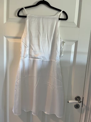 Klänning  - Fin vit klänning, säljs pga att den inte kommer till användning