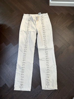 Jeans  - Säljer dessa vita jeans med snörning från HM i storlek 36