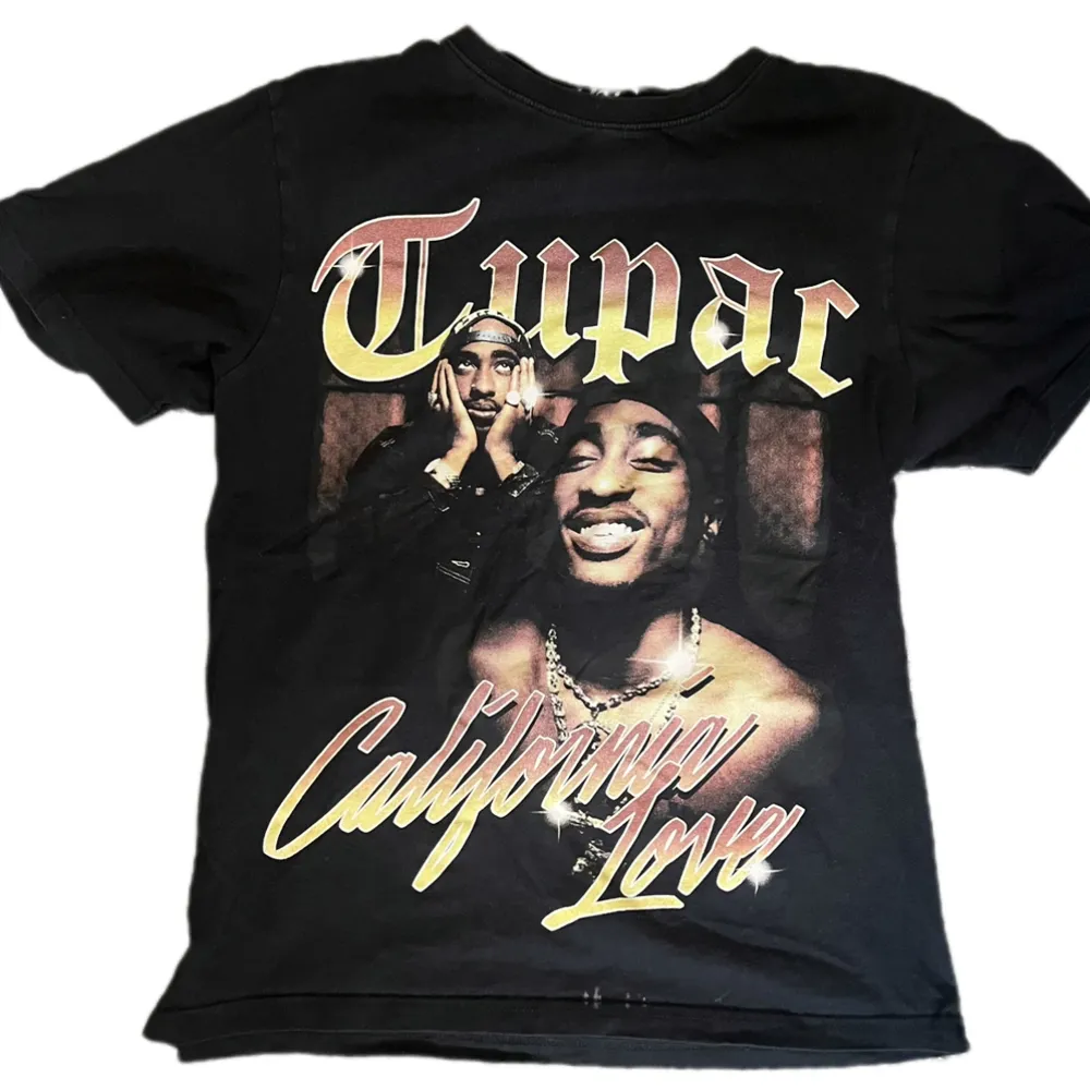 en svart tupac t-shirt från pull&bear storlek S i bra skick, de är lite fläckar längst ner på tröjan som man ser på första bilden annars helt perfekt skick . T-shirts.