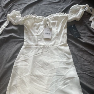 Vit klänning - Säljer nu min backup klänning från studenten ifjol, helt oanvänd med lappen kvar, superfin i storlek 32/xs. Pris 299kr