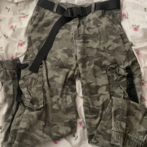 Cargo military byxor - Säljer då dom inte passar  Camouflauge byxor ifrån NewYorker. Använd nå flertals gånger men inga defekter eller hål. Behöver endast strykas då dom är lite skrynkliga :) Bälte går och ta av, ingår. Stora fickor fram på byxorna ❤️ !! Katter finns i hemmet !!