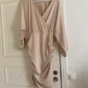 Beige bodycon klänning - En beige v-ringad bodycon klänning, använd 1 gång