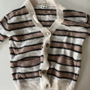 Acne Studios Alpaca Striped Cardigan - Acne Studios Pink striped alpaca Kedy cardigan by Acne Studios. V-neck. Ribbed edges. Buttoned closure. Contrasting buttons. 45% nylon 28% wool 27% alpaca