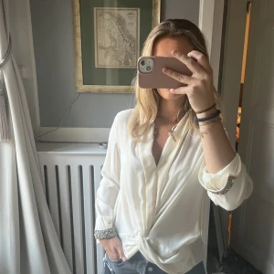 Vit blus med detaljer - Alla blusar 2 för 200! Säljer denna vita blus från Zara med detaljer längst ner på ärmarna då den är aningen liten på mig! Kan mötas upp i Stockholm, annars står köparen för frakt🤍