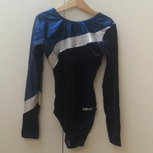 Gymnastikdräkt  - En tävlingsdräkt som är i bra skick med fina glittriga detaljer i sammet det finns tyvärr inga exakta storlekar på dräkten men den ska passa en 14 åring. 