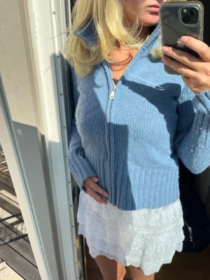 Stickad kofta - Blå stickad kofta med dragkedja. Lite nopprig som syns på bilderna men annars bra skick!