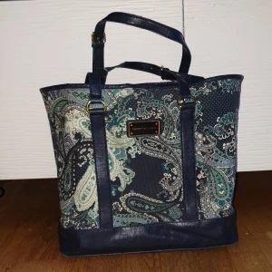 Tommy Hilfiger väska - Äkta Tommy Hilfiger väska, i bra skick dock är handtagen slitna. Men det medföljer en ny handtag/axelrems (se bild 3)