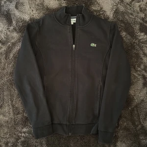 Lacoste tröja - Säljer denna lacoste tröja storlek S, den är för liten för mig. Skicket är bra, har minimal slitning pga tvätt men inget annat. 