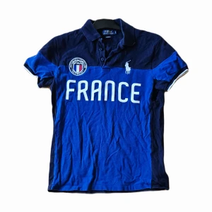 Ralph Lauren Piké - Ralph Lauren piké med franskt motiv i okej skick, den behöver strykas antagligen. Dunder pris. Storlek S. Nypris 1299kr