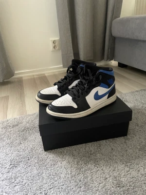 Air Jordan 1 mid white/racer blue-black - Skick: 9/10  Inte använda så mycket. Crease skydd medföljs Nypris: 3300