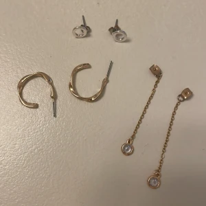 Örhängen - Säljer några fina blandade örhängen, ett par guldringar från h&m, ett par platta silver tror h&m och sedan ett par så fina pluppar med hänge som man sätter bakom några andra valfria örhängen. 100 kr för alla tre par. Möts i Stockholm helst Kungsholmen.