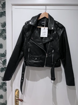 Skinnjacka (imitation) Pull & Bear - Skinnjacka imitation från Pull & Bear. Svart, storlek L. Aldrig använd och prislappen sitter kvar.