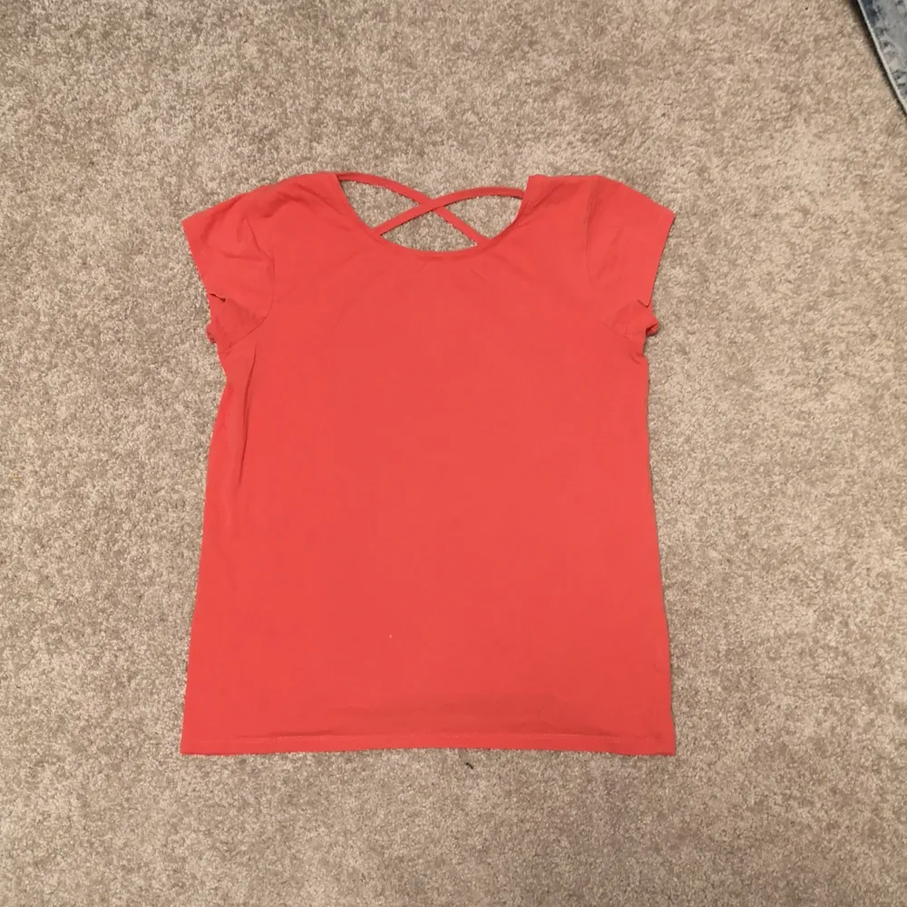 Jättefin T-shirt i en korallrosa färg. Har rors vid ryggen och är i nyskick. Storlek 170 från Linde kids. T-shirts.