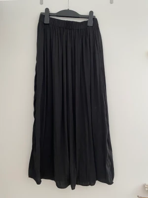 Midi kjol  - Midi kjol i glansigt material. Strl xs. Anvönd men i gott skick