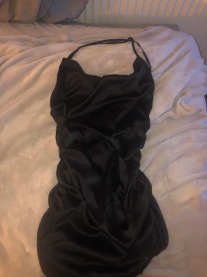 Svart klänning - Klänning från shein i silkes material med öppen rygg som går i kors super fin. 