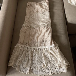 Lång kjol  - En längre kjol med massa söta detaljer på! Passar perfekt till semester eller nu till hösten! Bra material ( dubbeltyg). Längd 98cm