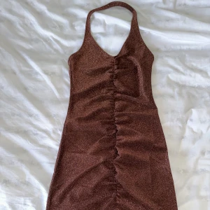 Glittrig klänning  - Jättefin glittrig klänning från H&M, oanvänd storlek XS. 
