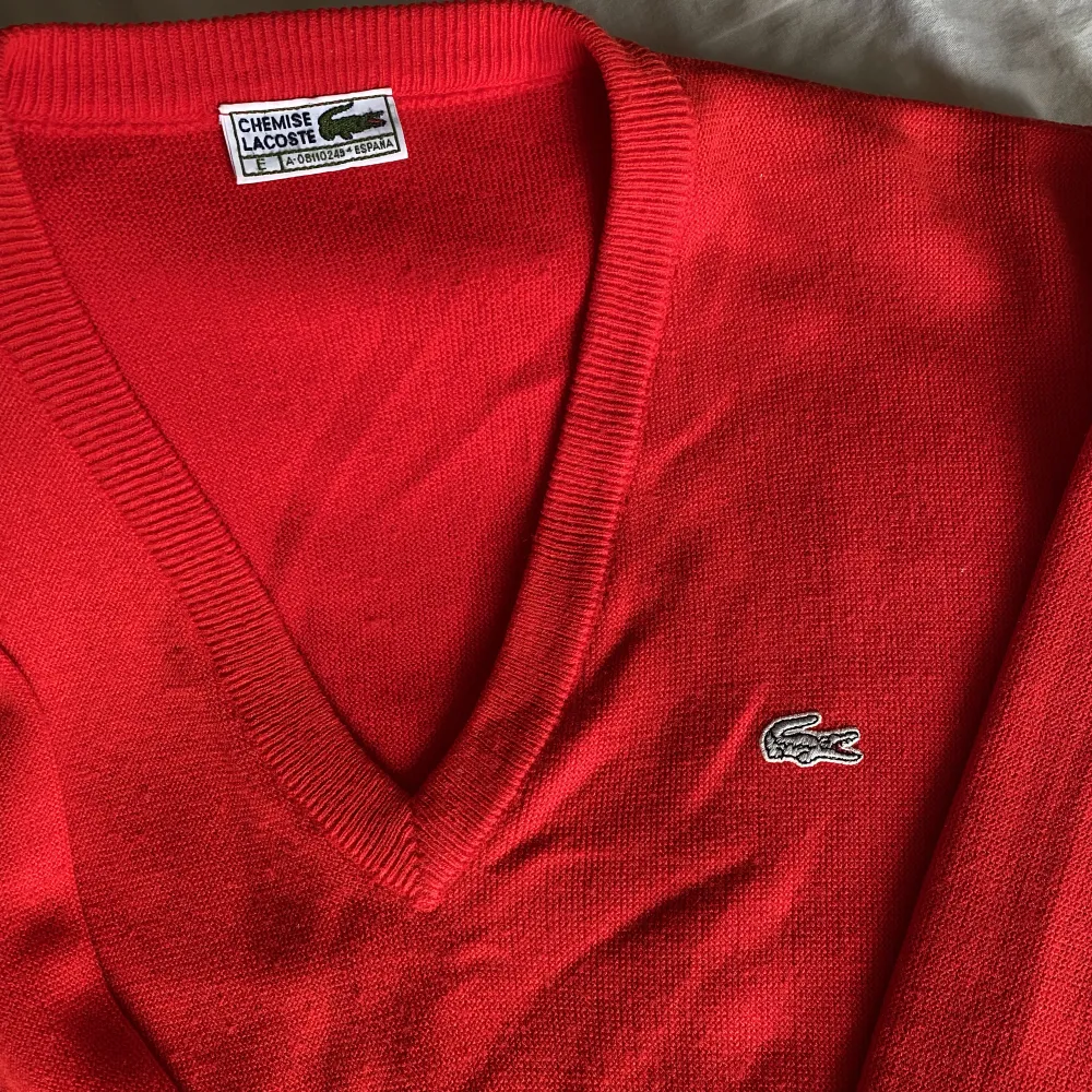Röd stickad tröja från Lacoste, lite nopprig men det är snabbt åtgärdat. Annars i jättefint skick! . Stickat.