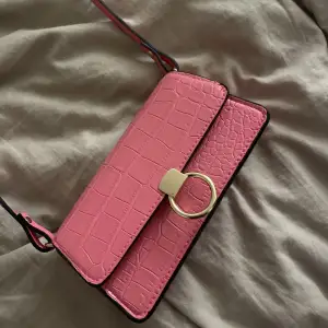 Hej jag säljer en skit gullig rosa väska som har guld detaljer på sig och är en mindre väska som är i ormskinns mönster och den är bara testad.