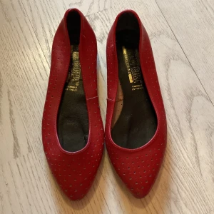 Vintage röda ballerinaskor!! - Vintage röda ballerinaskor i äkta skinn, samt  i jättebra skick, knappt använda. Så söta och somriga. Dessutom är de sköna och luftiga i och med de små hålen i skinnet. Tillverkade i Frankrike.