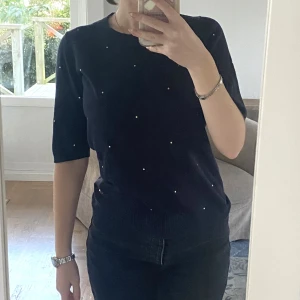 Mörkblå blus - Blus med gulddetaljer i strl s. Från Lindex. Har ett litet hål uppe vid högra axeln, annars bra skick.