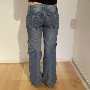 Lågmidjade cargojeans - Så coola jeans med massa fickor i utmärkt skick. Säljer då de inte är min stil längre. Midjemåttet tvärs över är 40cm och innerbenslängden 80cm💓
