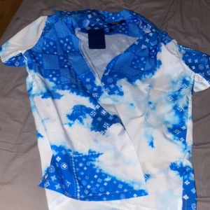 Blå louis vuitton skorta - Hej säljer min louis vuitton skorta i nytt  skick med taggen kvar sen är i storlek M men passar nästan S bättre den har inga hål eller liknade🙃(pris kan diskuteras vid snabb affär 