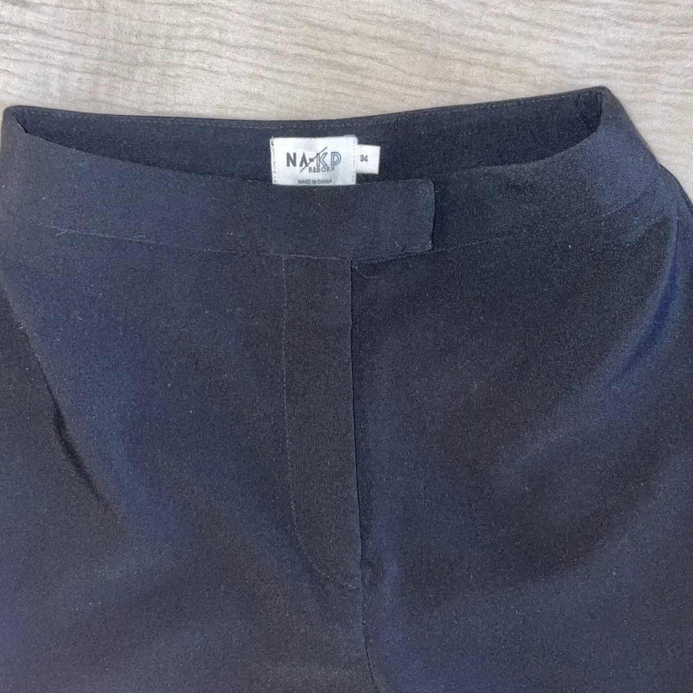 Kostymbyxor med slits från NAKD, storlek 34/XS. Använda en gång men tyvärr inte rätt passform för mig! Superfina 💓✨. Jeans & Byxor.