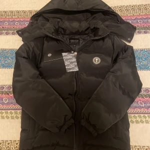 Trapstar Irongate Svart Jacka - Säljer min helt nya Trapstar Irongate Jacka, det är en rep, men ser precis likadan ut som den riktiga. Skick: 10/10, tags sitter kvar! Den är väldigt bekväm och varm inuti. Öppen för förhandling. För fler frågor samt bilder är det bara att höra av sig! 