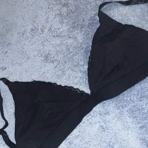 Detta är en svart bralette. Den är av bara tyg så ingen bygel. Den har spets runt sig och knäpps på samma sätt som en vanlig bh. Banden är även juster bara. Det står att storleken är 38 men den har en mindre passform. 