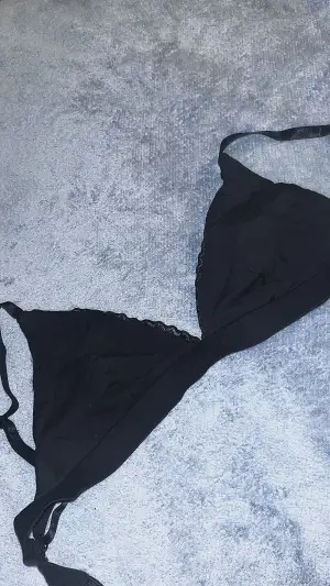 Detta är en svart bralette. Den är av bara tyg så ingen bygel. Den har spets runt sig och knäpps på samma sätt som en vanlig bh. Banden är även juster bara. Det står att storleken är 38 men den har en mindre passform. 